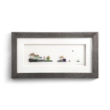 A gray wood framed image of a little village by the sea made of pebbles.