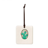 A square hanging tile ornament with a graphic image of a green cactus with pink flowers on a tan background.