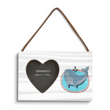 A rectangular hanging white wood frame ornament with a graphic image of a gray whale on a blue background with a 2x2 heart shaped opening for a photo.