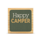 A square wood plaque with a dark green tile that says "Happy Camper".