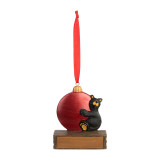 An ornament of a black bear hugging a large red ornament, hanging from a red ribbon. There is a spot in front for customization.