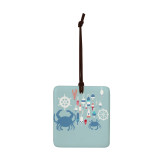 A square sea blue hanging tile magnet ornament with an illustration of buoys, crabs and ship wheels.