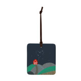 A square dark blue hanging tile magnet ornament with an illustration of a red barn on the hills.