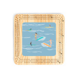 A light wood cribbage board with an illustration of surfers on the water.