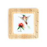 A light wood cribbage board with a watercolor image of a hummingbird and flower in the middle.