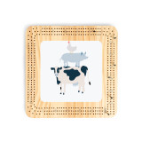 A light wood cribbage board with an illustration of a cow, pig and chicken in the middle.