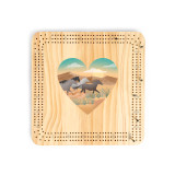 A light wood cribbage board game with heart shaped graphic artwork of running horses in a southwest setting in the middle.