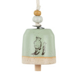 A mini tan and green bell with an image of Pooh and Piglet walking together. There are beads and a metal token at the top of the bell.