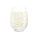 A clear stemless wine glass with a colorful confetti pattern all around the glass.