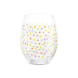 A clear stemless wine glass with a bright colorful confetti pattern all around the glass.
