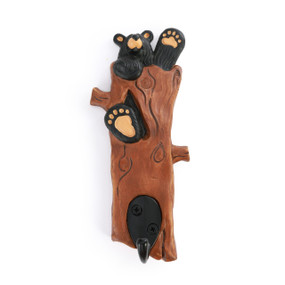 Wall hook that looks like an upright log with a black bear waving out the top. The single black hook is at the bottom.