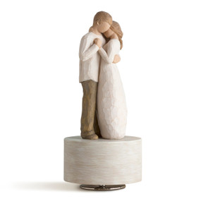 Male and female couple figures embracing as if dancing, standing atop cream wood base