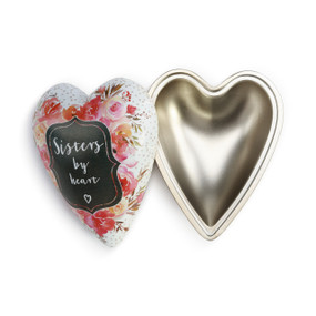 A white and gold art heart with pink flowers, pink polka dots, and "sisters by heart".