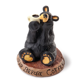 Small black bear figurine sitting on wooden plaque