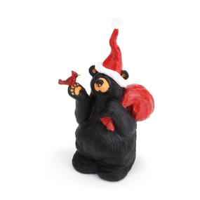 Front view of black bear figurine wearing red hat and holding red bird