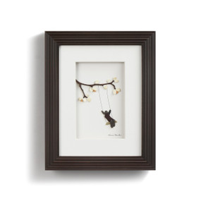 pebbles and seaglass depicting child swinging on branch on white background with dark frame