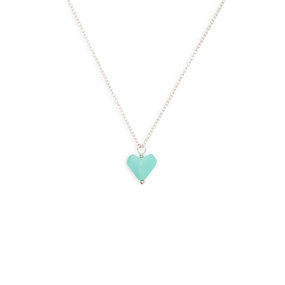 A close up image of the blue pebble pendant in the shape of a heart on a silver necklace.