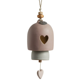 A white and light pink Inspired Bell" with a heart shape cut out, a light pink dangling charm, a silver pendant that reads "mom", and a white cord string with wooden beads."