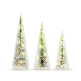 A set of three illuminated glass tree figures in staggering sizes. Each a cone of glass filled with an illuminated Christmas tree and faux snow. Placed from tallest to shortest.