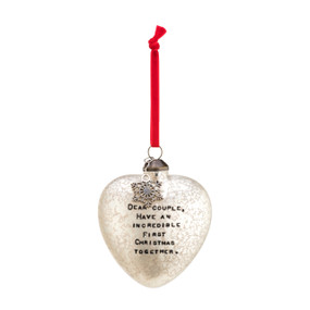 A frosted glass heart shaped ornament with a silver snowflake charm, a red velvet string, and "Dear couple, have an incredible first Christmas together."