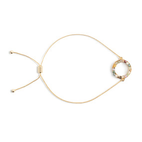 An adjustable gold bracelet with a circle of small green and gold stones attached.