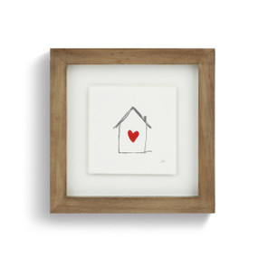 A square wood framed scribble art of a house with a red heart inside.