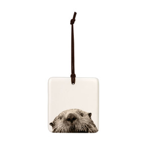 A white square tile hanging ornament with the image of an otter.