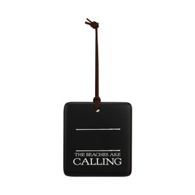A square black hanging ornament that says "The Beaches are Calling" in white under two white lines with room for personalization.