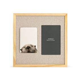 A light wood frame with a white tile on the left with the image of an otter next to a 4x6 photo opening with a linen mat.