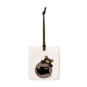 A white square hanging ornament with a black bear peeking over a tree stump with Washington on it.