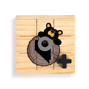 A square wood tic tac toe board with a black bear looking over a tree stump with Nevada on it, with a gray O and black X on top.