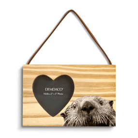 A rectangular wood hanging ornament with a heart shaped 2 inch photo opening next to an image of an otter.