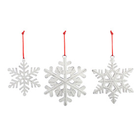 A set of three distressed white metal snowflake ornaments in different sizes and patterns.