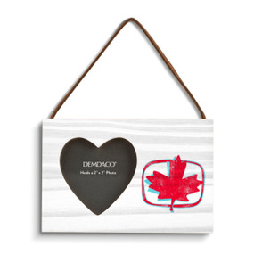 A rectangular hanging white wood frame ornament with a graphic image of a red maple leaf and a 2x2 heart shaped opening for a photo.