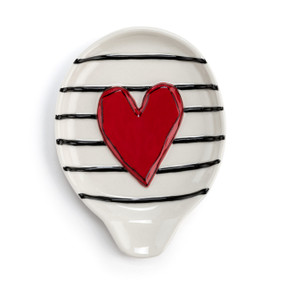 A cream stoneware spoon rest with black stripes and a raised red heart.