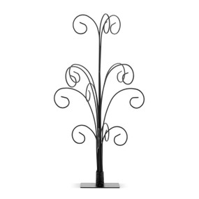 A black metal ornament stand that resembles a tree with multiple hangers coming up and curling to create a way to display multiple ornaments.