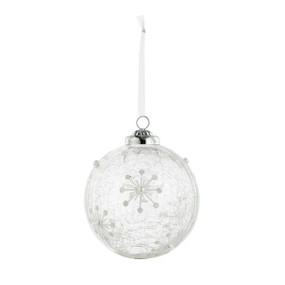 A hanging white glass ornament decorated with snowflakes.