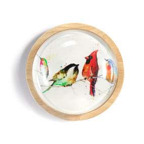 A light wood round paperweight with a glass dome over a watercolor image of songbirds on a branch.