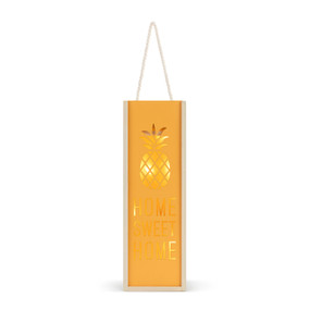 An illuminated orange and light wood tall box that says "Home Sweet Home" with a pineapple cut out of the wood, with a rope handle.