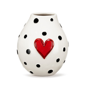 A white ceramic vase with a raised red heart on the front and black dots around the vase.