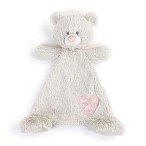 A cream blankie with the face of a bear that has a light pink nose. The blankie has a light pink fabric heart shaped patch near the foot.