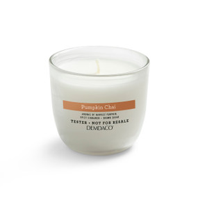A white tester candle in a clear glass container with a pumpkin chai scent.