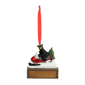 An ornament of a black bear riding on a snow machine, hanging from a red ribbon. There is a spot in front for customization.