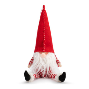 A seated red and white fabric gnome figure with a long white beard and red pointed hat.