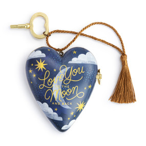 A heart shaped musical sculpture in a dark blue night sky pattern that reads "Love You to the Moon and Back". The heart has a bronze tassel and gold key attached.