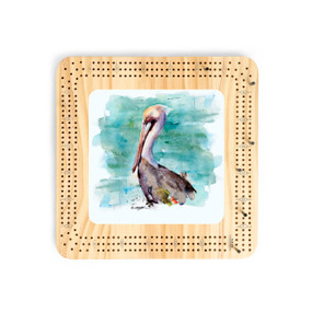 A light wood cribbage board with a watercolor image of a pelican in the center.
