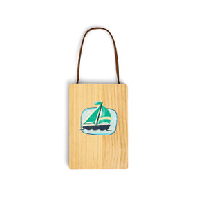 A wood hanging gift card ornament with an illustration of a green sailboat on a light green background on the front. The back has a holder for a gift card.