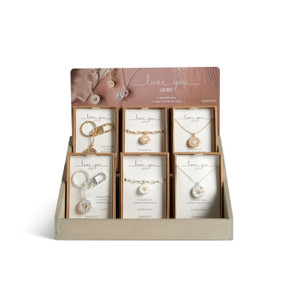 A gray wood two tier tabletop displayer holding an assortment of Love You Locket jewelry in packaging boxes.