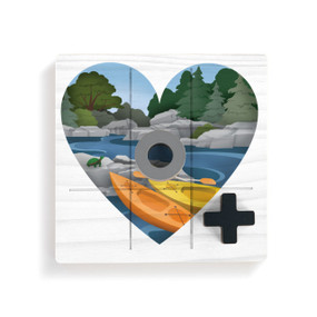 A square white wood board for tic tac toe with heart shaped graphic artwork of kayaks at a rivers edge, displayed with a gray O and black X on top.