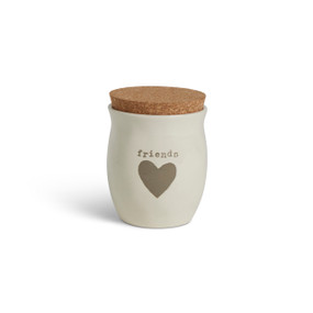 A cream ceramic candle with a gray heart and the word "friends". The candle has a cork lid.